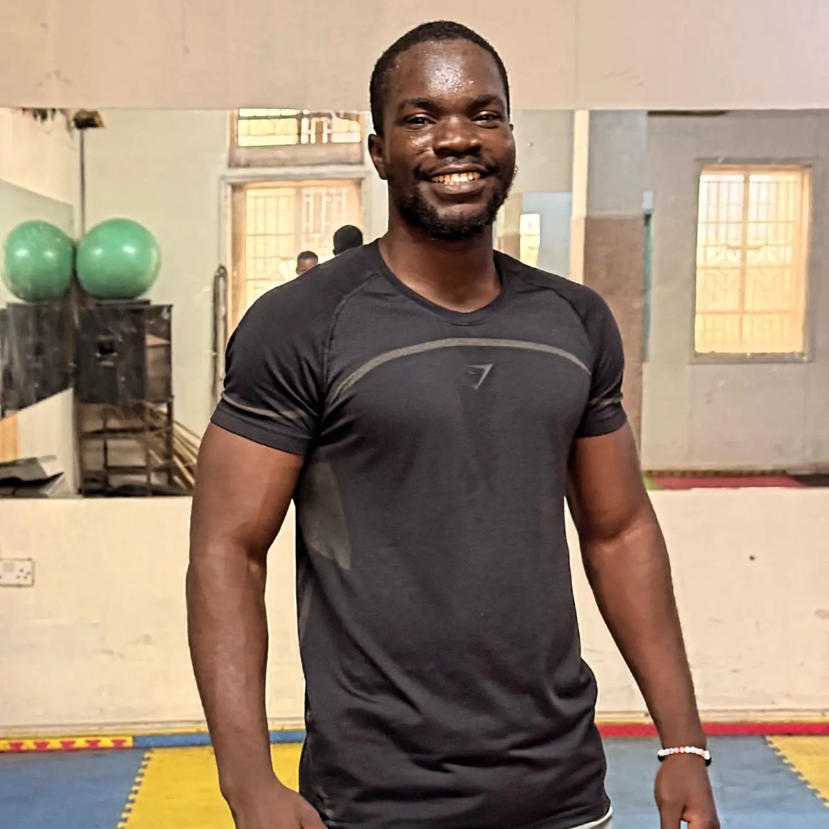 Don Michael Ondiro, certified personal trainer in Nairobi, smiling in the gym