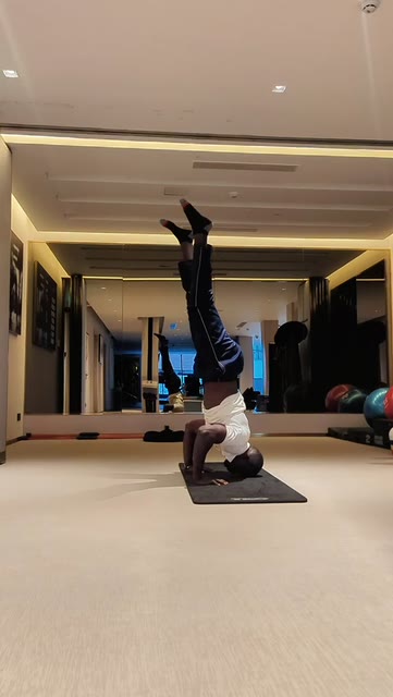 Coach Don holding a tripod headstand during calisthenics training in a Nairobi gym