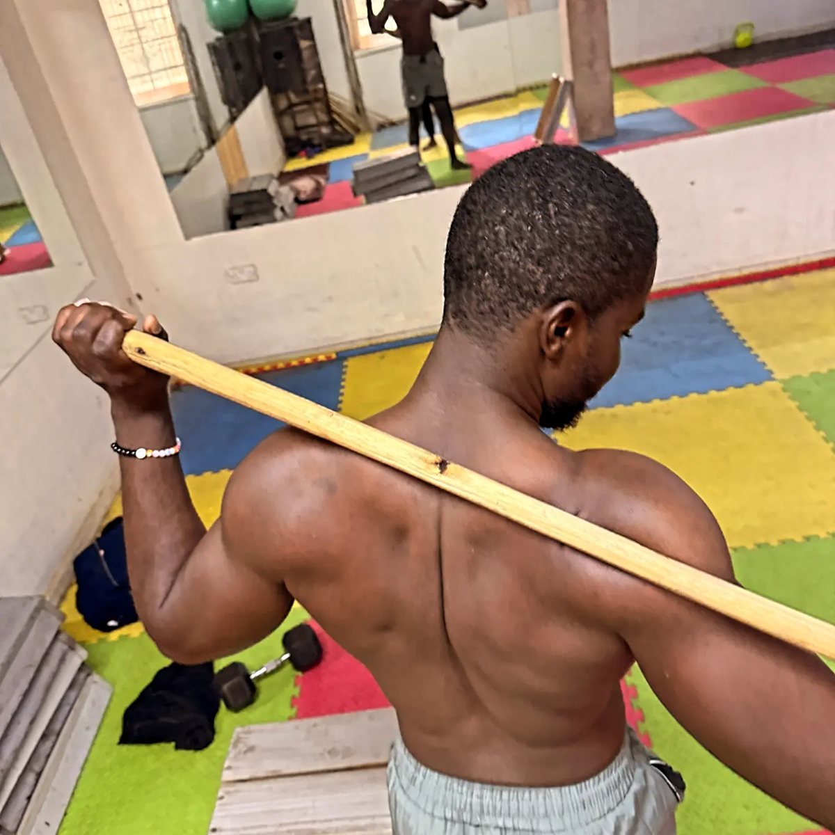 Shoulder mobility drill with a training stick at a Nairobi gym